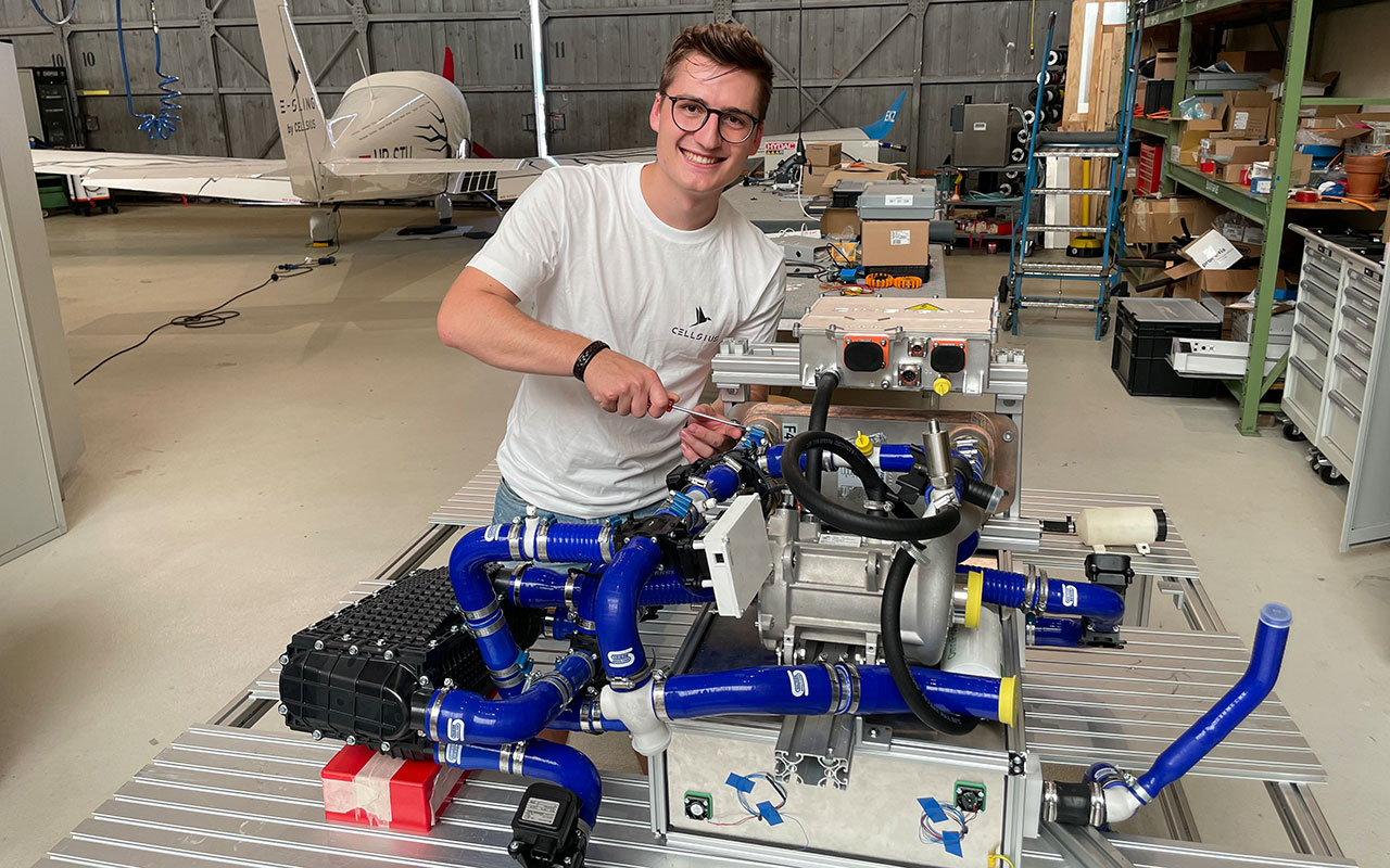 Markus Metzler (Team Lead) am neuen Brennstoffzellensystem im Hangar vor dem e-Sling Flugzeug © Avenergy